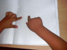 Manos de niño leyendo braille